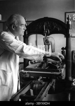 Dec. 09, 1965 - le maître munichois de l'art graphique et graveur sur bois Josef Weiss travaille encore sur la plus ancienne imprimerie du monde, une du type que Gutenberg utilisait déjà. Il est artiste, imprimeur et éditeur en une seule personne, ses livres sont les seuls encore entièrement réalisés à la main. Certaines de ses œuvres nécessitent du travail pendant un an. Notre photo montre l'élève de Gutenberg Weiss qui travaille à l'œuvre de Hoelderlin, un célèbre poète allemand. (Crédit image : © Keystone Press Agency/ZUMA Press Wire) Banque D'Images