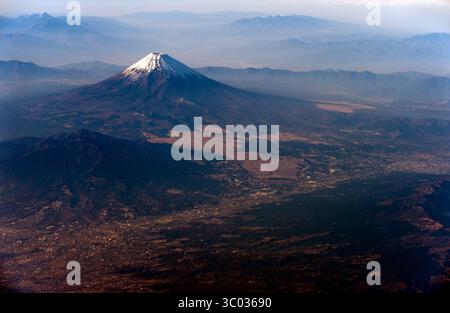 Vue aérienne du mont Fuji sacré enneigé, le plus haut sommet du Japon, vu d'un avion survolant la préfecture de Shizuoka au Japon. Banque D'Images