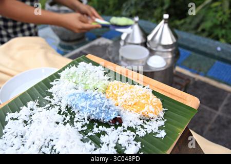 Khanom Tua Pap est un dessert thaïlandais coloré. À l'intérieur se trouve une garniture de soja ou de haricot rouge, saupoudrée de noix de coco râpée et de sucre Banque D'Images