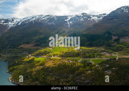 Hardanger Bridge enjambe gracieusement un vaste corps de fjord avec des montagnes imposantes formant une toile de fond spectaculaire. Pont suspendu moderne avec des tours proéminentes Banque D'Images