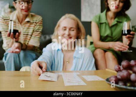 Femme caucasienne d'âge moyen lisant des cartes de Tarot avec deux copines Banque D'Images