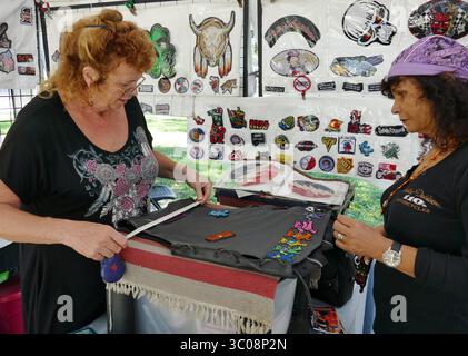 15 octobre 2018 - New Port Richey, Floride, États-Unis - MICHELE MILLER | TIMES.Eilleen Ceder, a tendance à la cliente, Cecelia Murdock, de Dunedin, pendant le Cotee River Bike Fest, tenu du 12 au 14 octobre, dans le centre-ville de New Port Richey..''C'est notre première fois ici, je suis venu spécifiquement pour trouver quelqu'un qui pouvait coudre sur des patchs,'''' a dit Murdock..elle a eu de la chance en trouvant Ceder, 59, qui offre un service de spécialité des patchs de couture sur place en utilisant un couple de machines à coudre à pédale antique qu'elle apporte sur la route avec elle. (Crédit image : © Michele Miller/Tampa Bay Times via ZUMA Wire) Banque D'Images