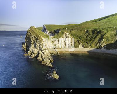Vue aérienne des falaises de craie blanches accidentées rencontrant la mer bleu profond, créant un contraste saisissant de textures et de tons, Durdle Door, Wareham, Angl Banque D'Images