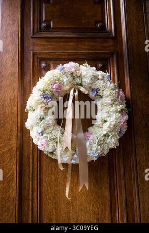 Couronne de mariage floral avec ruban sur porte en bois Banque D'Images