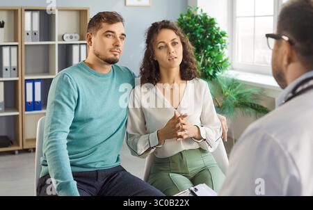 Couple visitant le médecin, couple consultant à la clinique, expliquant les dossiers médicaux, donnant des informations Banque D'Images