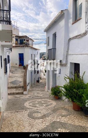 FRIGILIANA, ESPAGNE - 10 MAI 2025 : une promenade paisible dans les charmantes rues étroites, entourées de maisons blanchies à la chaux et de fleurs colorées à Frigil Banque D'Images