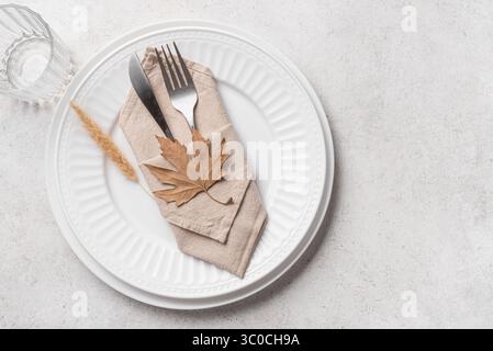 Thanksgiving Day ou Halloween cadre élégant avec feuille d'érable sèche sur fond de béton blanc, vue de dessus, espace de copie. Table blanche de vacances d'automne Banque D'Images