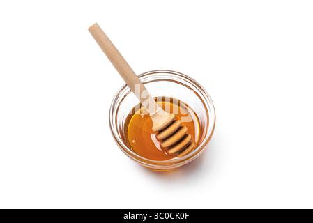 Miel dans un bol en verre avec un plongeur de miel isolé sur fond blanc, élément de design. Miel naturel. Banque D'Images