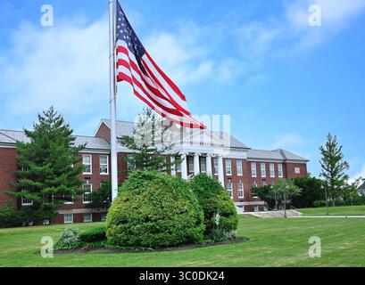 Bâtiment scolaire de style classique avec grand drapeau américain sur la pelouse avant Banque D'Images