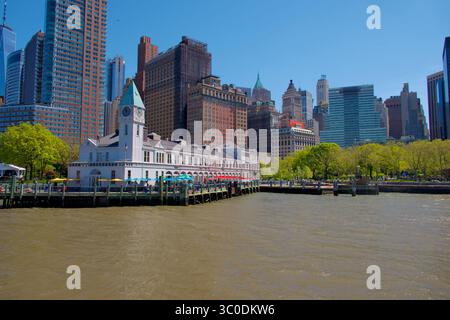 Historique Pier A Harbor House à Battery Park, New York City, avec horizon et front de mer sous la lumière du soleil printanier. Banque D'Images