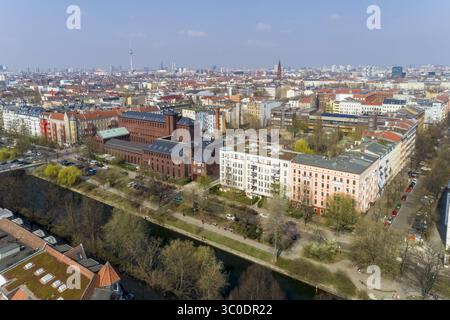 Vue aérienne des bâtiments en briques contrastant avec les appartements modernes et le lointain Fernsehturm, baigné dans la douce lueur d'un jour de printemps, Berlin, Berlin, Allemagne. Banque D'Images