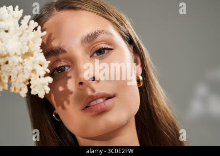 Une jeune femme à la peau bronzée met en valeur sa beauté naturelle dans un studio d'été. Banque D'Images