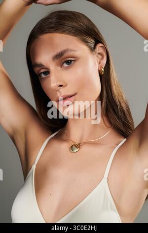Une jeune femme magnifique à la peau bronzée profite d'une ambiance estivale dans un studio, rayonnant de beauté. Banque D'Images