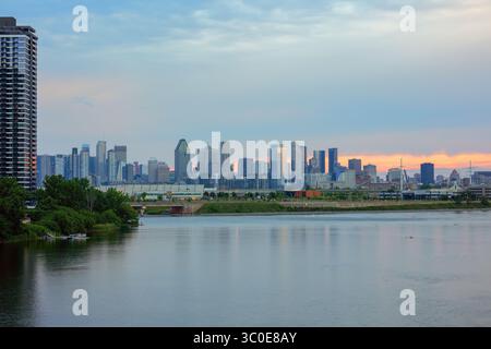Superbe horizon du centre-ville de Montréal reflété dans les eaux calmes du fleuve Saint-Laurent à l'heure dorée. Magnifique paysage urbain Québec Canada avec des tours modernes Banque D'Images