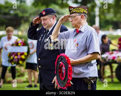 11 novembre 2018 - Kanchanaburi, Kanchanaburi, Thaïlande - JERRY KARWACKI, (à droite) du poste des vétérans des guerres étrangères à Bangkok, Thaïlande, salue un vétéran du Commonwealth britannique lors de la pose de gerbes lors de la cérémonie du jour de la remise en état au cimetière de guerre de Kanchanaburi, Thaïlande. Kanchanaburi est l'emplacement du tristement célèbre ''pont sur la rivière Kwai'' et était connu pour le ''chemin de fer de la mort'' construit par le Japon pendant la seconde Guerre mondiale utilisant des prisonniers de guerre alliés, principalement britanniques, australiens et néerlandais, comme esclaves. Il y a 6 982 personnes enterrées dans le cimetière, in Banque D'Images