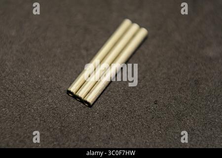 Gros plan de trois espaceurs d'écartement étroitement agencés sur une surface sombre Banque D'Images