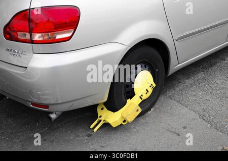 Gros plan d'une voiture avec une pince de roue sur la route, Paris, France Banque D'Images
