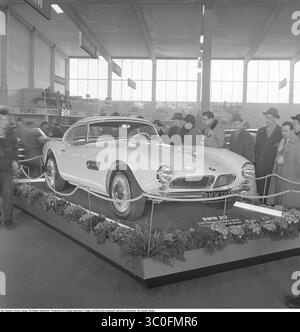 Exposition automobile 1956. Le salon annuel de l'automobile, Bilsalongen, se tient à Storängsbotten, où le hall d'exposition nouvellement construit abrite des voitures particulières. Des foules curieuses se rassemblent autour du nouveau modèle du constructeur allemand BMW, la BMW 507. Avec un moteur V8 à soupapes en tête de 3,2 litres développant 140 chevaux, il atteint une vitesse de pointe de 220 km/h. - La BMW 507, lancée en 1956, était un roadster de luxe conçu par Albrecht von Goertz, destiné à concurrencer la Mercedes-Benz 300SL. Seulement 252 unités ont été produites, ce qui en fait un classique rare aujourd'hui. réf. BV85-3 Banque D'Images