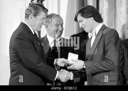 Le président américain Ronald Reagan présente Steve Jobs, co-fondateur américain d'Apple Computer, Inc, avec le National Technology Award 1985 dans la salle est de la Maison Blanche le 19 février 1985. (ÉTATS-UNIS) Banque D'Images