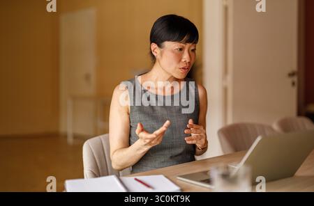 Portrait d'une femme professionnelle sérieuse discutant de projets en appel vidéo à l'aide d'un ordinateur portable au bureau d'entreprise Banque D'Images