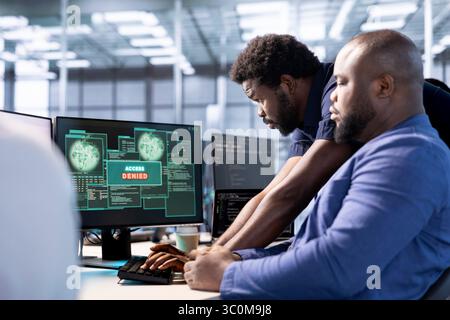 Employé demandant de l'aide au responsable après avoir reçu une notification contextuelle de refus d'accès alors qu'il essayait d'optimiser le concentrateur de serveur. Gestionnaire de centre de données aidant le travailleur à ne pas éliminer les erreurs réseau Banque D'Images