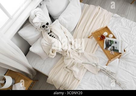 Modèle de squelette humain avec peignoir et plateau dans la chambre, vue de dessus Banque D'Images