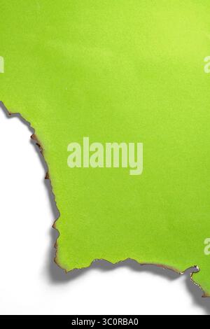 Papier vert déchiré message déchiré avec bords brûlés isolé sur un fond blanc. Copier l'espace Banque D'Images