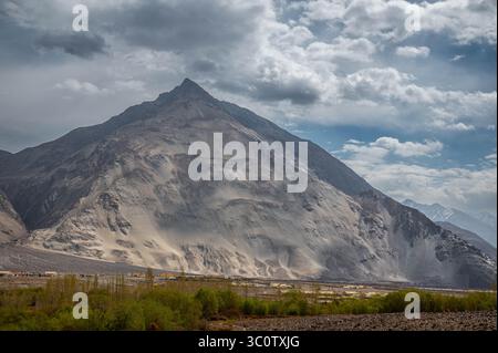 Paysage himalayen majestueux avec des pics arides, une végétation de contreforts et la trajectoire asséchée de la rivière Shyok dans le Ladakh, en Inde. Banque D'Images