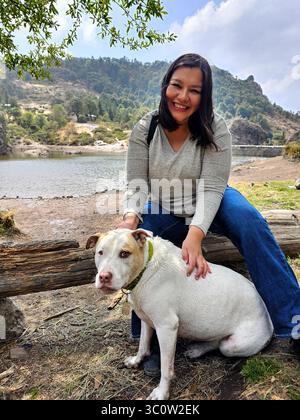 Une femme adulte latina passe du temps à l'extérieur avec son chien de soutien émotionnel comme thérapie pour le stress et l'anxiété Banque D'Images