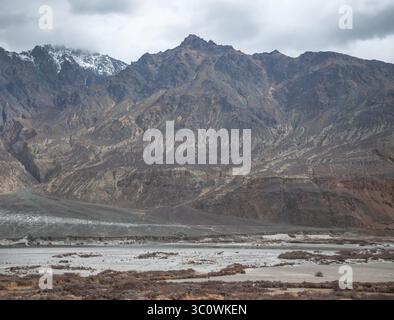 Paysage himalayen majestueux avec des pics arides, une végétation de contreforts et la trajectoire asséchée de la rivière Shyok dans le Ladakh, en Inde. Banque D'Images