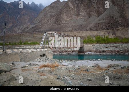 Pont métallique sur la rivière Shyok au Ladakh, en Inde, avec une eau bleue claire et des montagnes majestueuses de l'Himalaya créant un paysage naturel époustouflant. Banque D'Images