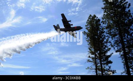 Le 26 avril 2018 - Californie (É.-U.) - Un avion C-130 Hercules équipé d'un système modulaire de lutte contre les incendies aéroportés du Service forestier de l'USDA jette de l'eau au-dessus de la forêt nationale Tahoe, Calif., le 26 avril 2018. Les quatre ailes de transport aérien militaires chargées de soutenir la mission MAFFS du ministère de la Défense ont participé à la formation annuelle de recertification parrainée par le Service des forêts du 22 au 27 avril. Cette année, l'entraînement s'est terminé à la McClellan Reload base à Sacramento avec les quatre ailes recertifiées avec succès et préparées pour la saison des incendies à venir. Les quatre ailes de transport aérien, trois Air National Guard et Banque D'Images