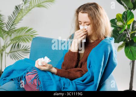 Maladie, concept de problème de virus saisonnier. Femme malade ayant la grippe couchée sur le canapé. Femme malade couchée dans le lit avec une forte fièvre. Grippe froide et migraine. Banque D'Images