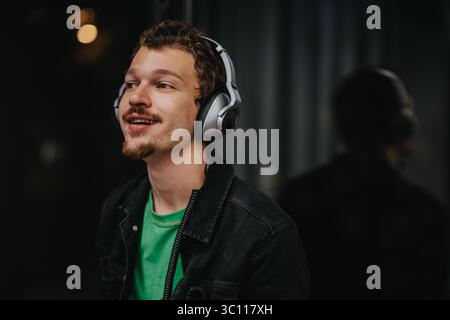 Jeune homme appréciant la musique avec des écouteurs dans une atmosphère détendue Banque D'Images