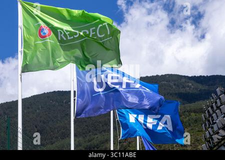 Drapeaux promouvant le respect de l'uefa et de la fifa agitant gracieusement contre un magnifique paysage montagneux sous un ciel nuageux spectaculaire Banque D'Images