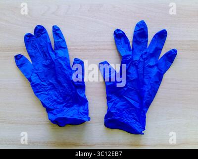 Paire de gants en latex médicaux jetables bleus sur fond clair. Remèdes de protection contre les virus. Vue de dessus. Gros plan. Mise au point sélective. Banque D'Images