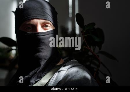 Portrait d'un homme portant Black Balaclava regardant vers l'avant Banque D'Images