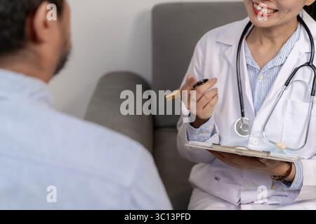 Une femme médecin professionnelle fournit des conseils en matière de santé et d'autosoins à un patient, favorisant le bien-être, la confiance et la communication médecin-patient. Banque D'Images