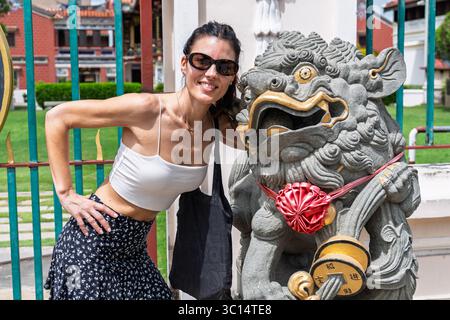 Une touriste posant à côté d'une statue traditionnelle chinoise dans la ville de George Town, Penang, Malaisie. Banque D'Images