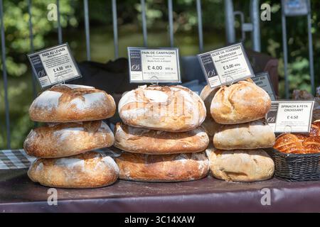 Piles de pain frais croustillant à vendre sur un étal de marché Banque D'Images