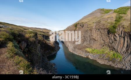 Explorez la beauté époustouflante du canyon Studlagil en Islande, avec ses imposantes colonnes de basalte et sa rivière tranquille. Banque D'Images