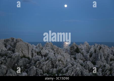 Rochers au bord de la mer et de la pleine lune, Cap Martin, près de Menton, Alpes Maritimes, Provence Alpes Côte d'Azur, Côte d'Azur, Sud de la France, France Banque D'Images