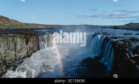 Selfoss, l'une des cascades les plus puissantes d'Europe, située sur un terrain accidenté avec un arc-en-ciel pittoresque au-dessus de ses eaux en cascade, créant un spectacle époustouflant en Islande Banque D'Images