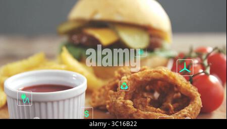 Affichage du cheeseburger sur la table à manger, à côté des frites, rondelles d'oignon, ketchup, tomates cerises Banque D'Images