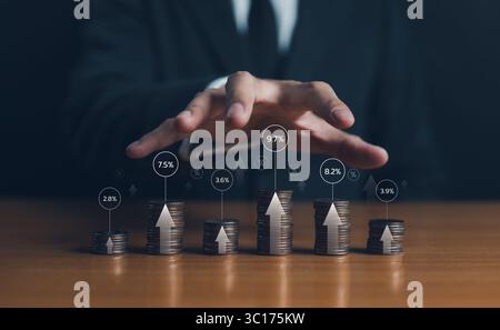 Concept d'augmentation du taux d'intérêt. Augmentation du coût d'emprunt d'argent auprès d'institutions financières telles que les banques. Homme d'affaires empilant les pièces diffèrent haut Banque D'Images