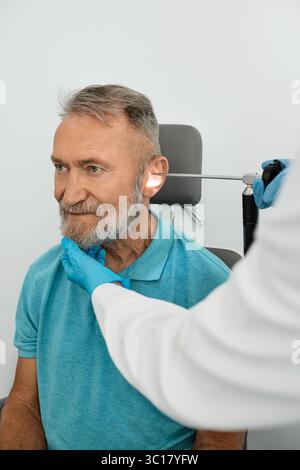 Un homme âgé se fait passer un examen de l'oreille à la clinique ORL avec un otolaryngologiste utilisant un endoscope vidéo. Endoscopie de l'oreille Banque D'Images