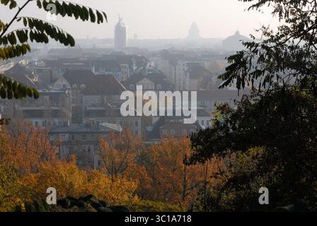 Vue sur les toits et les arbres d'automne colorés à l'horizon de la ville de Leipzig par une journée brumeuse. Banque D'Images