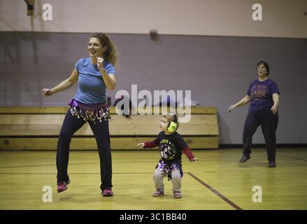 9 novembre 2016 - Minneapolis, MN, U.S.A - Laura Wilhelm a amené sa fille, Annola, 2 ans, à la classe de Zumba mercredi soir. Annola suit les cours avec sa mère depuis avant sa naissance. ....Il y a dix ans, dans l'un de ces moments de marche-la-parole, Allina Health a lancé un grand programme de bien-être pour servir les gens vivant dans le quartier autour de son siège social sud de Minneapolis sur Lake Street. La soi-disant initiative Back Yard a été un flop : elle était descendante, et les voisins n'ont jamais acheté. Depuis lors, ils ont essayé de le reconstruire à partir de zéro, et maintenant un peu funky Banque D'Images