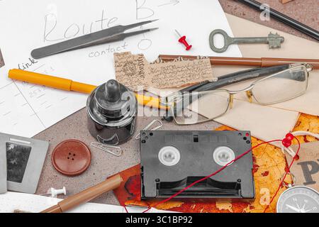 Espace de travail créatif sur le thème OSINT avec des outils vintage, des notes manuscrites et des éléments de presse sur une table grunge. Accessoires thématiques, pose à plat, gros plan Banque D'Images