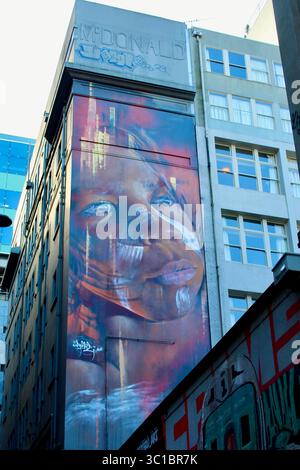 Peinture murale d'art de rue représentant un enfant aborigène peinte sur le flanc d'un bâtiment à Hosier Lane, Melbourne. Banque D'Images